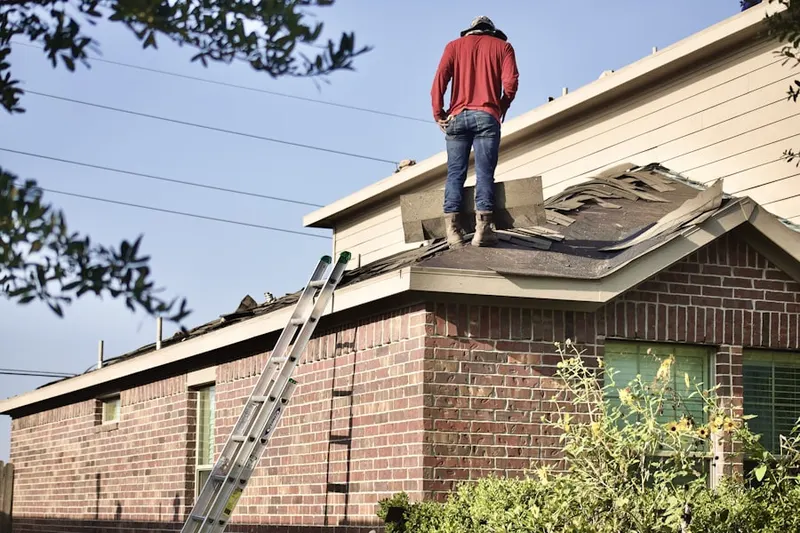 Professional roofer working on a residential roof in Warsaw